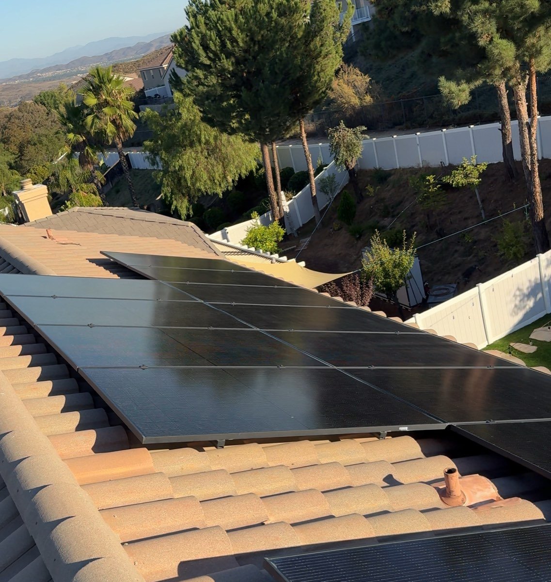 Clean solar array on a hillside roof at golden hour overlooking Lake Elsinore
